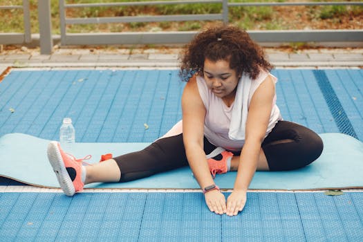 Young woman in activewear stretching on blue yoga mat outdoors, promoting fitness and healthy lifestyle.