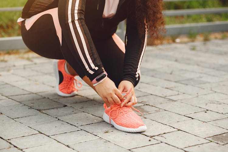 Woman In Sports Clothing Tying Her Shoe