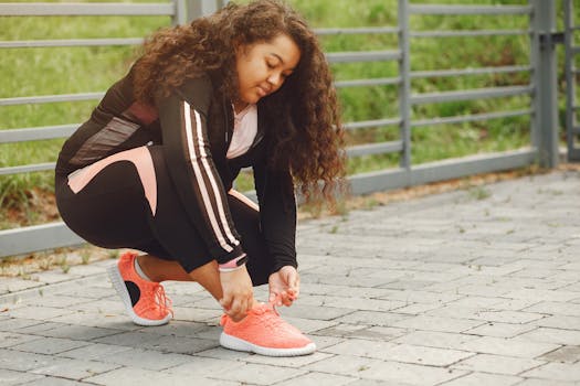 A woman ties her sneakers in preparation for an outdoor workout, promoting fitness and lifestyle.