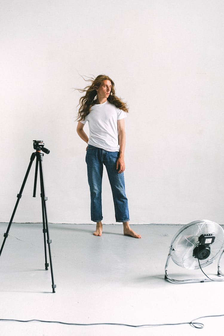 Man With Long Hair Standing In Studio During Photo Session