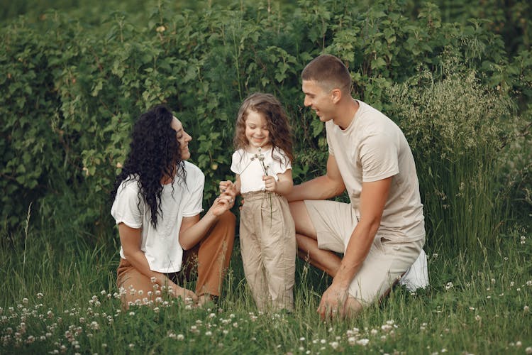 Family On Field Picking Up Flowers 