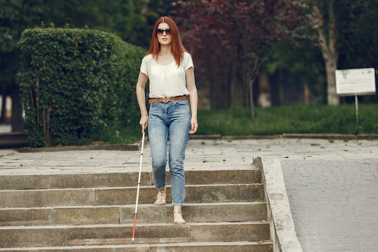 Blind Woman Walking Down Stairs With Her Cane