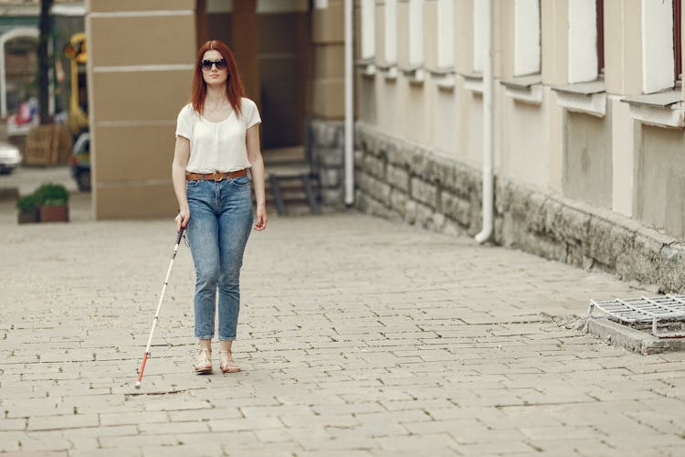 Shallow Focus Of A Blind Woman Walking On The Concrete Floor With Her Cane