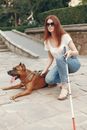 Woman in White Shirt and Blue Denim Jeans Sitting Beside Brown Short Coated Dog