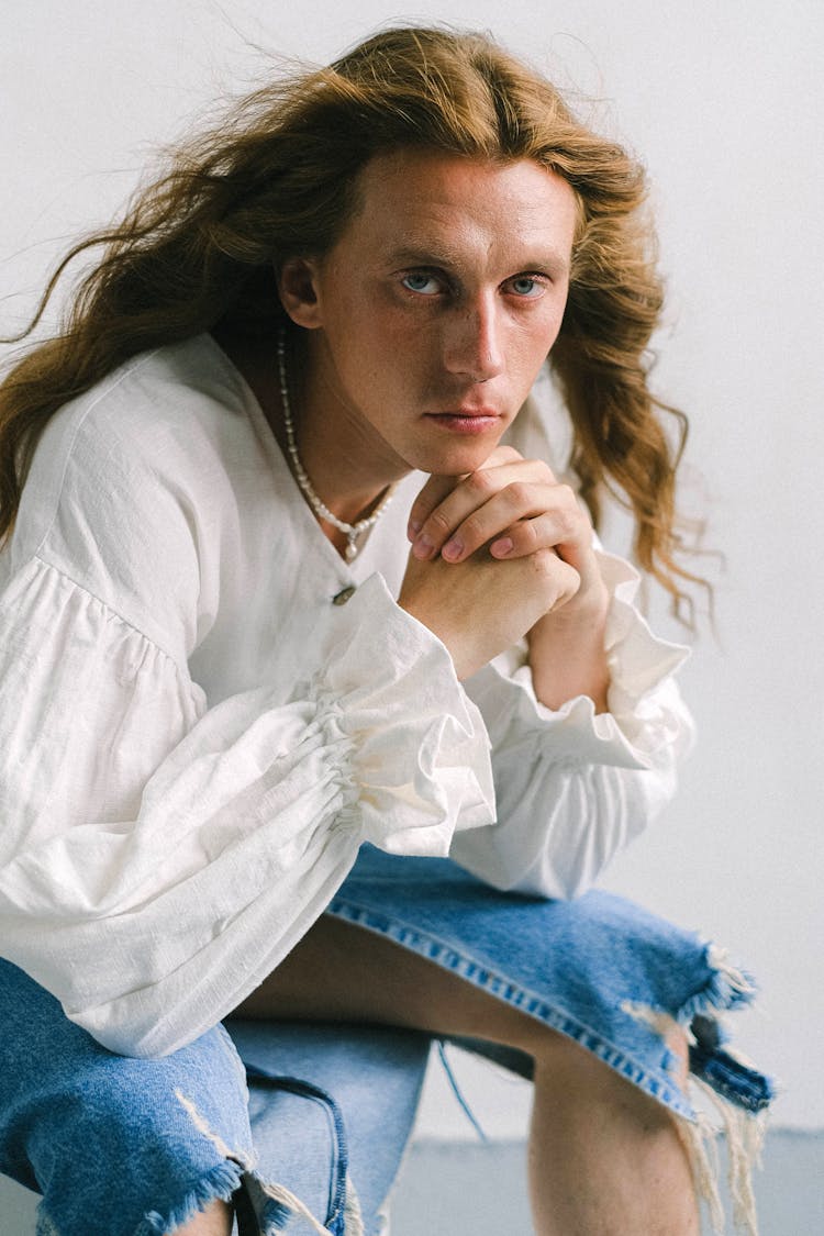 Serious Young Androgynous Male In Feminine Outfit Looking At Camera