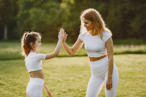 Free A Woman Doing a High Five with her Daughter at a Park Stock Photo