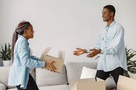 A Woman Handing a Cardboard Box to a Man