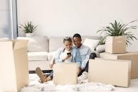 A Young Couple Sitting in a Living Room Full of Cardboard Boxes
