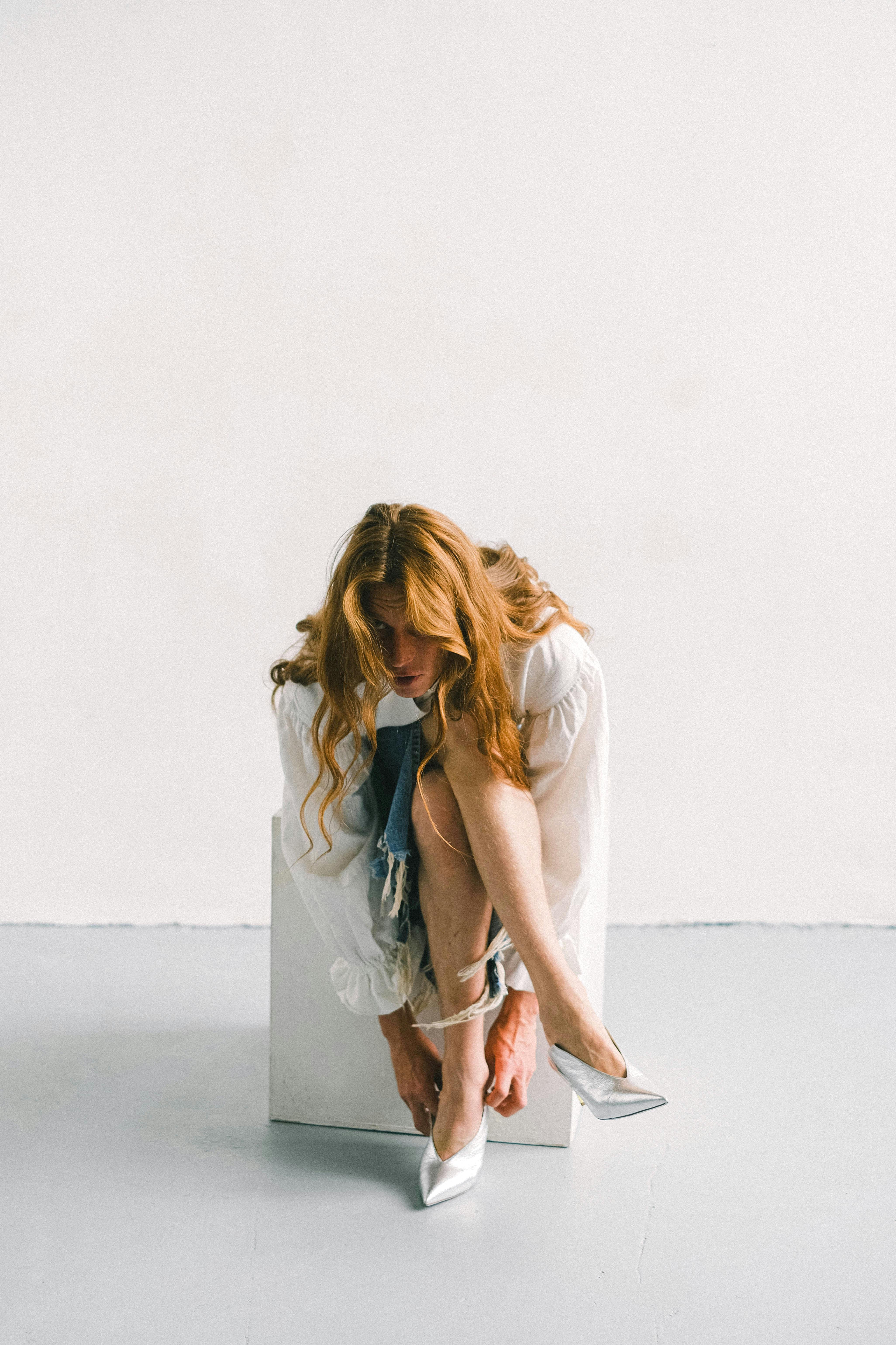 anonymous young man wearing trendy female shoes in studio