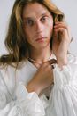 Tranquil young transsexual man touching hair and looking at camera