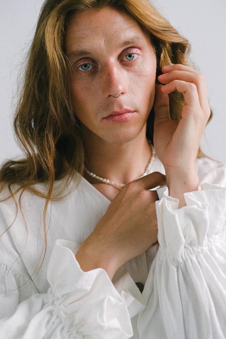 Tranquil Young Transsexual Man Touching Hair And Looking At Camera