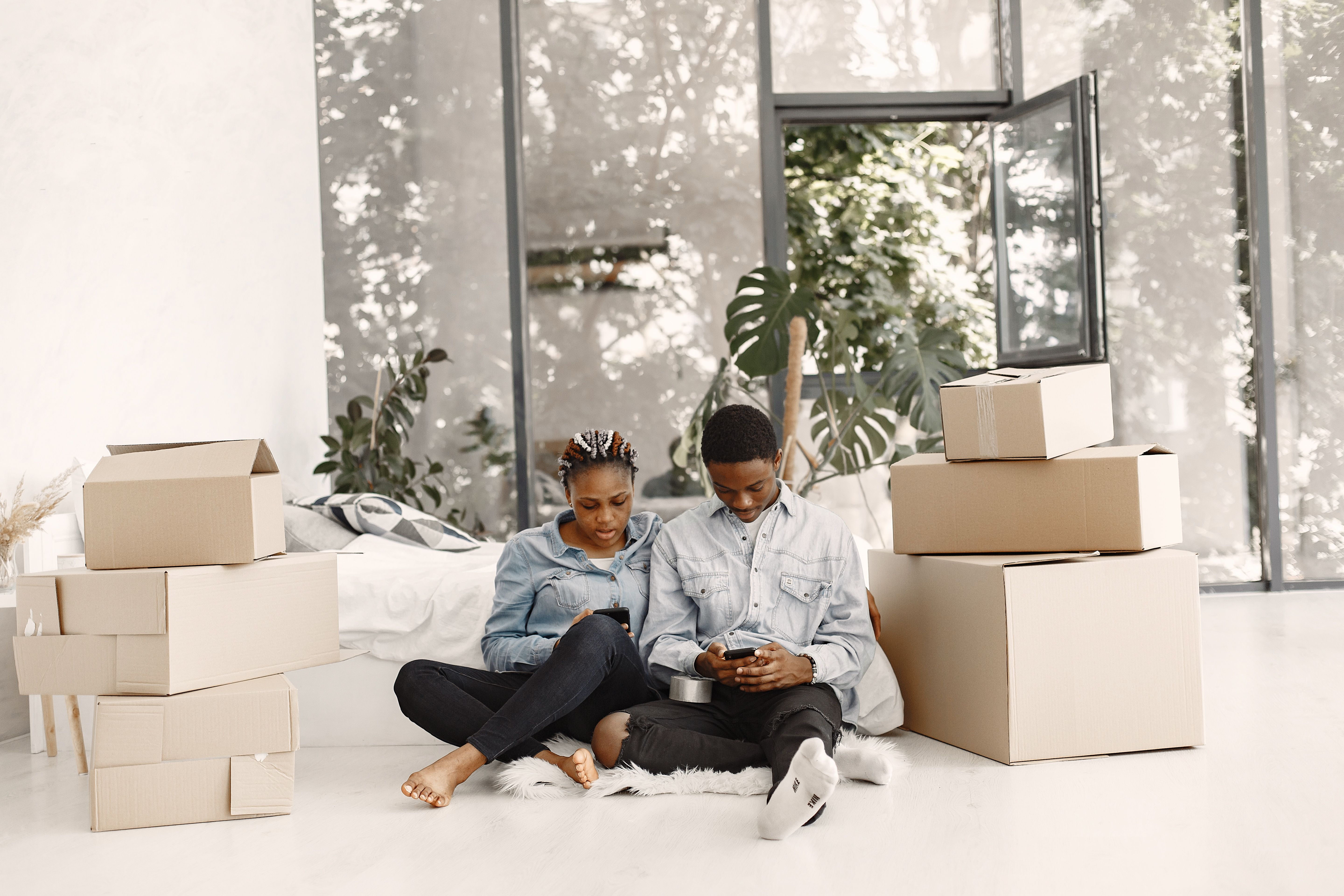 Group of young Black Nigerian friends in a Birmingham living room sorting a shared bulk grocery delivery, bags of crayfish and dried prawns laid out on a wooden coffee table, warm evening light, photorealistic
