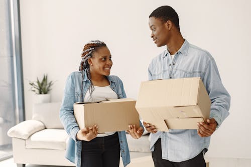 Free A Happy Couple Holding Cardboard Boxes Stock Photo