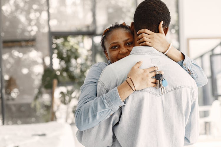 A Woman Hugging A Person While Holding A Bunch Of Keys