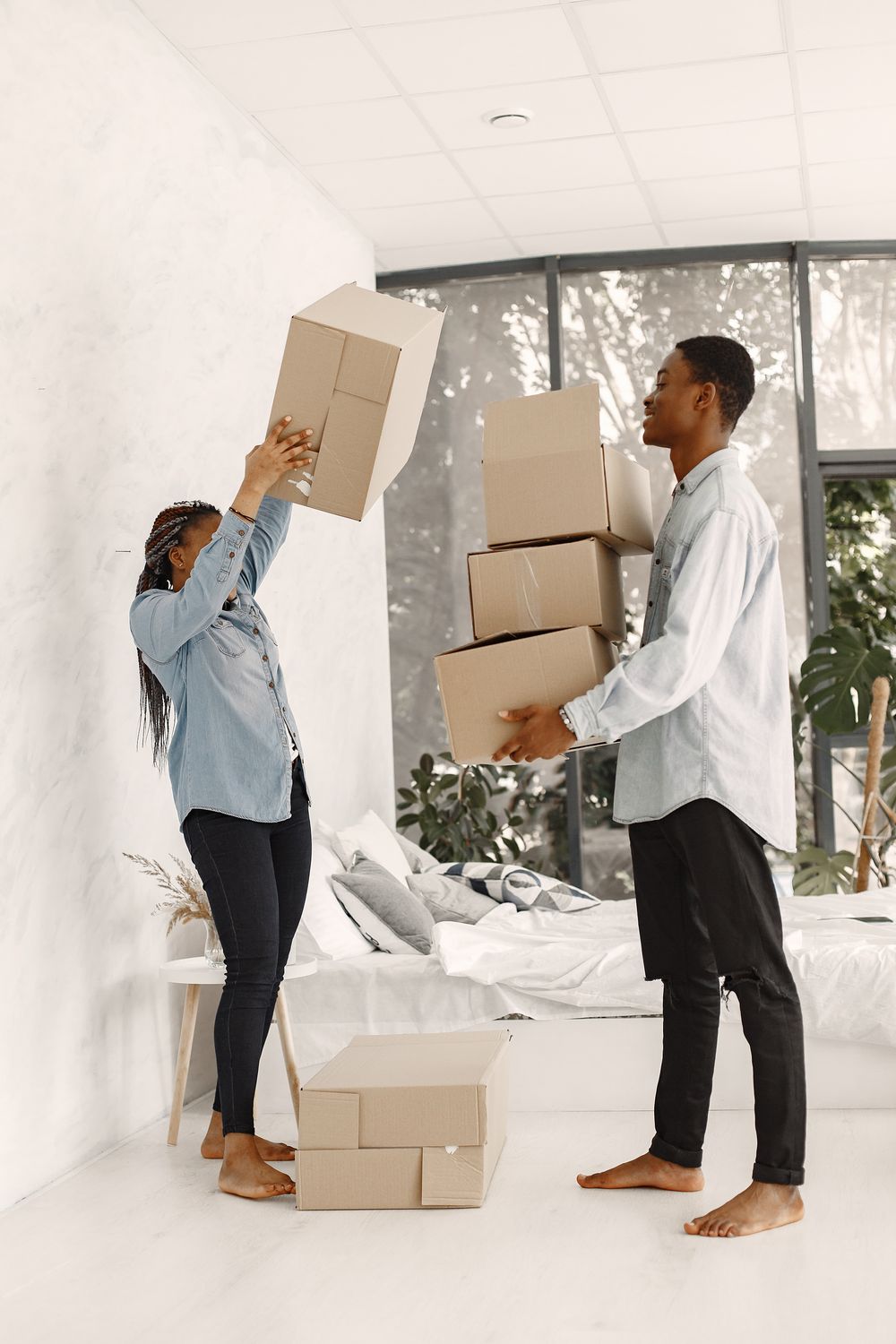 A couple carrying boxes into their new home