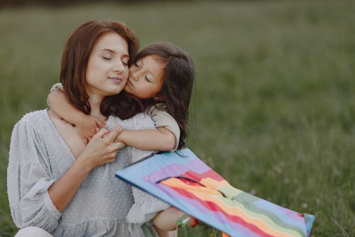 Free A Little Girl Hugging her Mother from Behind Stock Photo