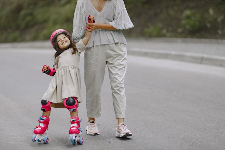 A Parent Teaching Her Daughter How To Rollerblade