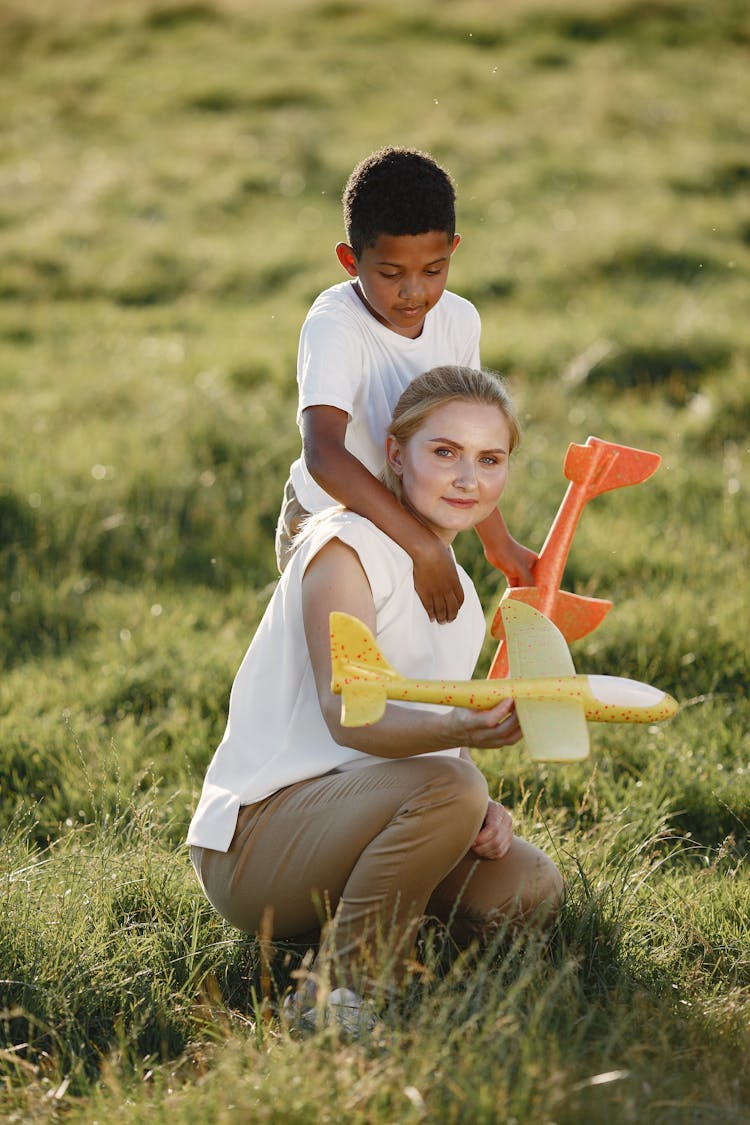 Mother And Son Playing With Toy Planes