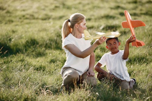Free Woman Playing with Boy with Toy Planes Stock Photo