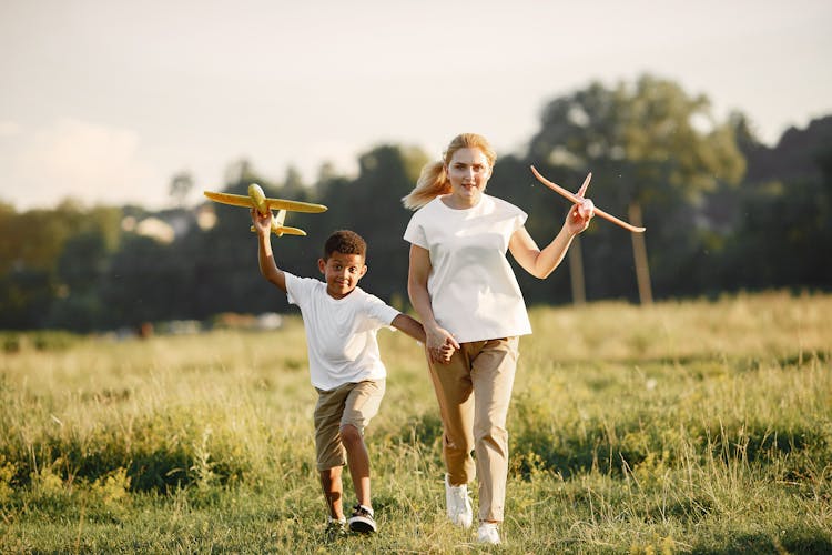 Mother And Son Running With Toy Planes