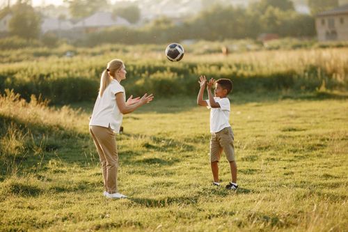 Free Two kids enjoying a game of catch in a sunny field. Outdoor fun. Stock Photo