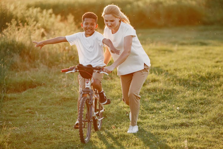 Mother Teaching Son How To Ride Bike