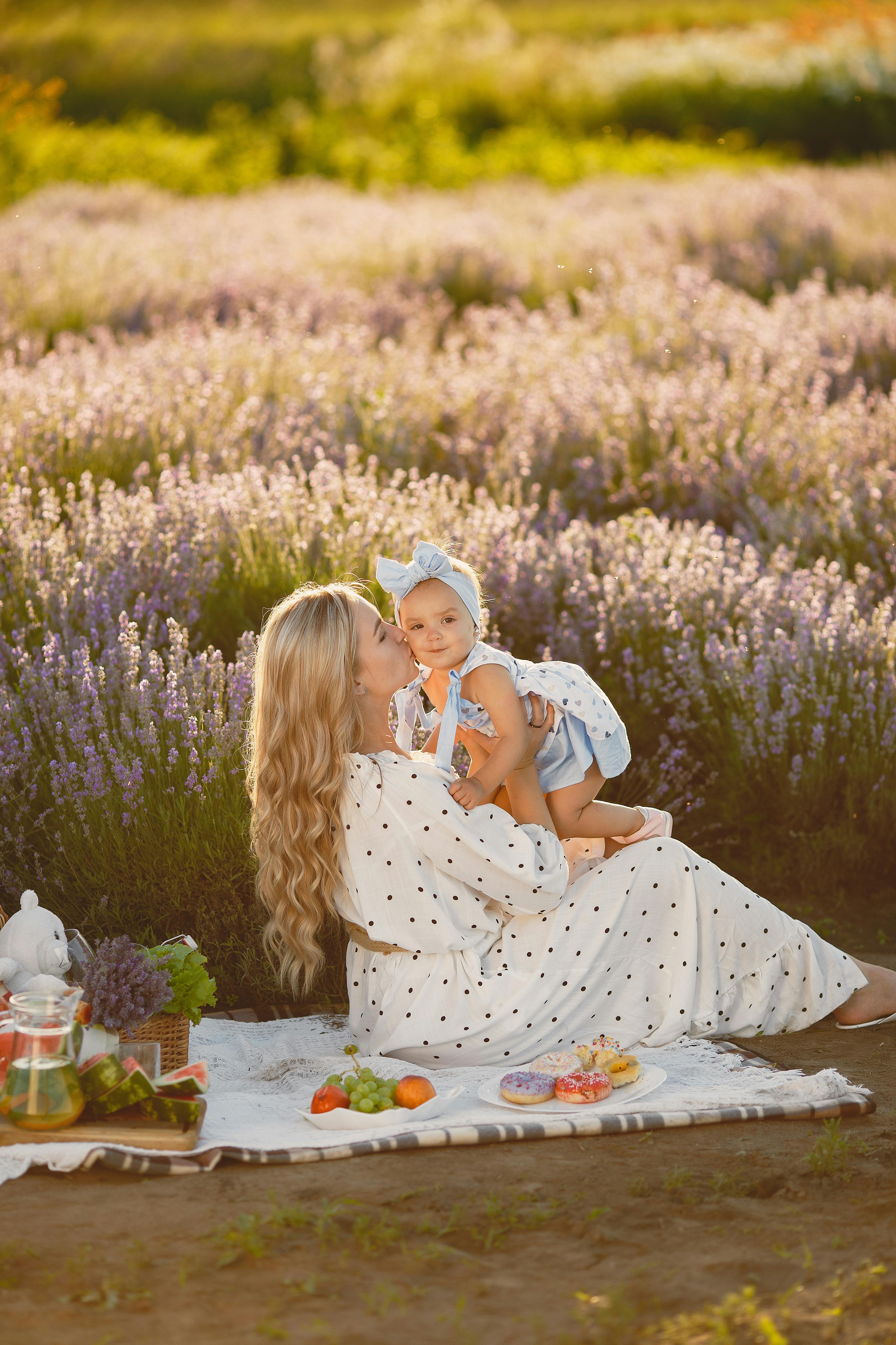 夏日，母亲和婴儿在宁静的薰衣草田野中野餐，一起放松身心
