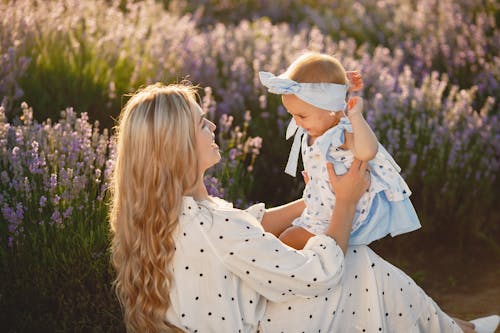 A Woman Holding a Baby in a Lavender Field