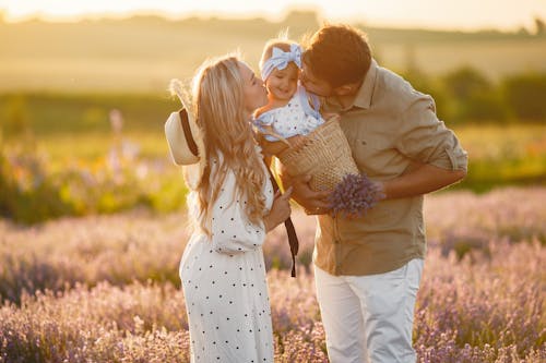 A Couple Kissing their Child in a Lavender Field
