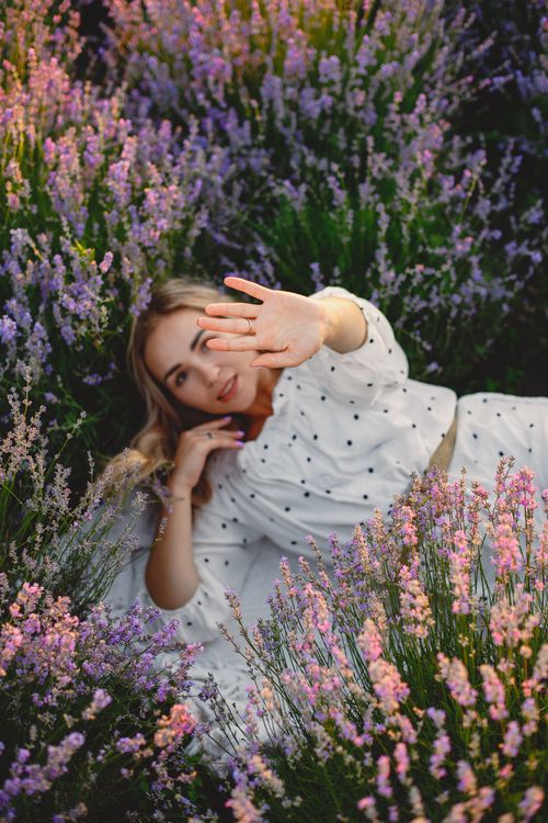 Free Woman enjoying peaceful relaxation in a lush lavender field, capturing serene summer vibes. Stock Photo