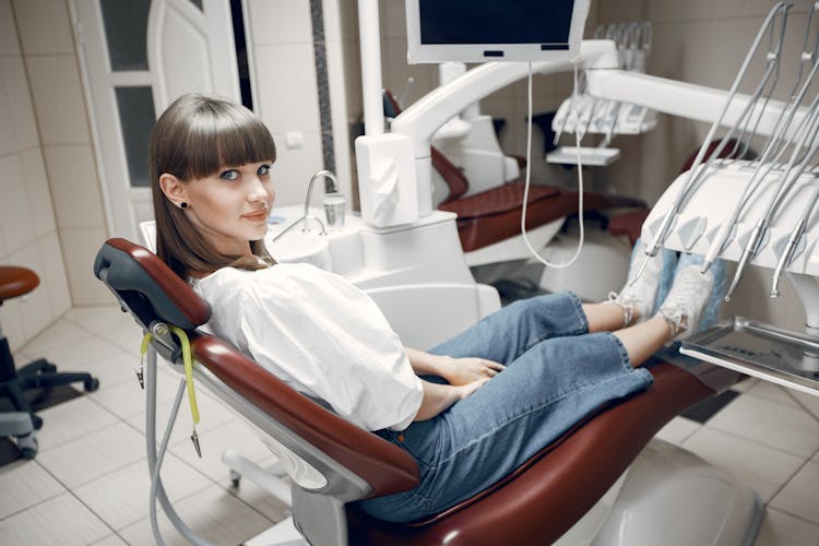 Young Woman Sitting In Dentist Chair