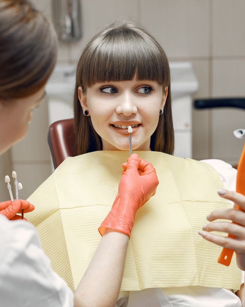 Relaxed adult talking with a dentist in a softly lit clinic
