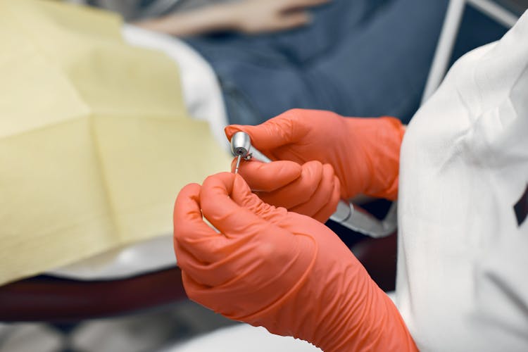 A Dentist Holding A Dental Drill