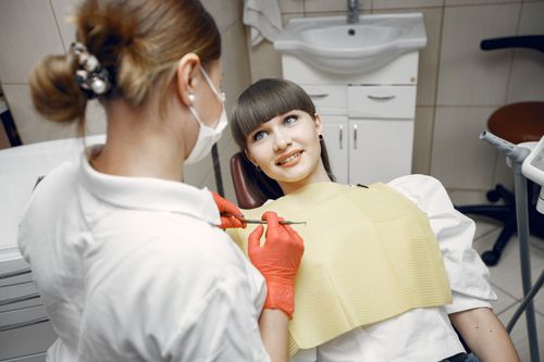 Free A dentist wearing a mask examines a patient in a contemporary dental office setting. Stock Photo