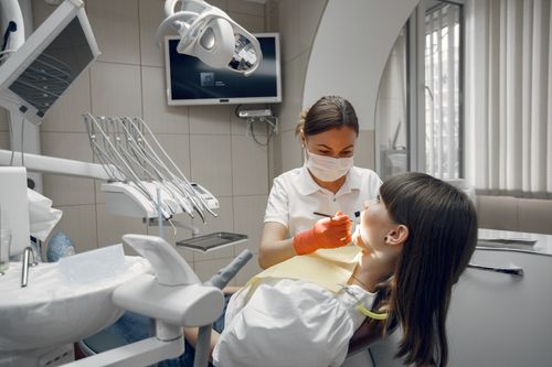 Free Dentist performing dental examination on female patient in modern clinic. Stock Photo