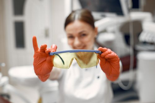 Free Focused dental worker showcasing protective eyewear in clinic. Stock Photo