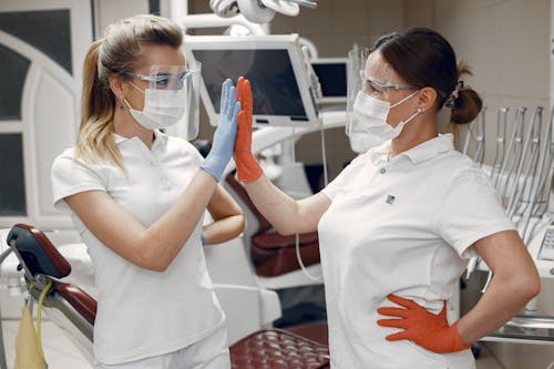 Women in White Polo Shirts Doing High Five