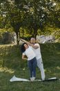 一对夫妇在户外郁郁葱葱的绿树背景下练习瑜伽