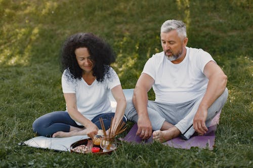 A Man and a Woman Sitting on Yoga Mats