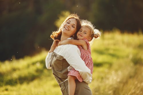 Free A Woman Giving a Piggy Back Ride to her Daughter Stock Photo