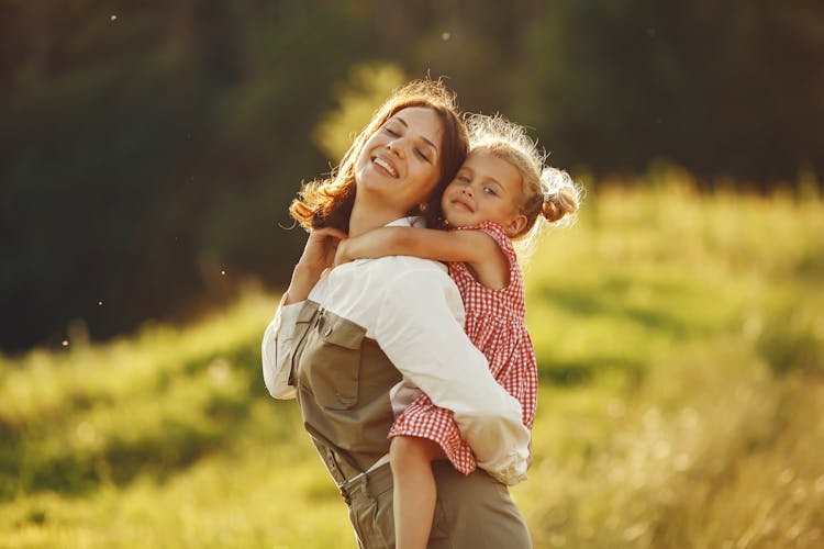 A Woman Giving A Piggy Back Ride To Her Daughter