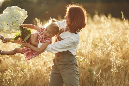 Free A Woman Playing with her Daughter in a Field Stock Photo