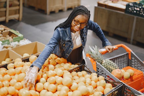 Smiling Woman Choosing Fruit in Supermarket