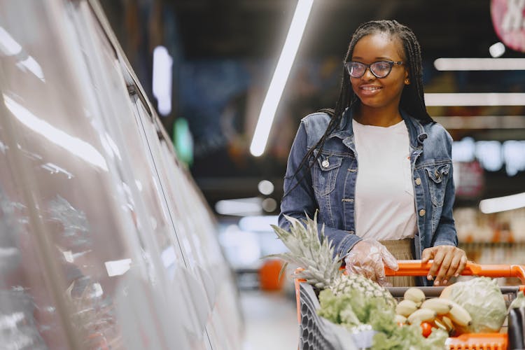 Smiling Woman Grocery Shopping In Supermarket