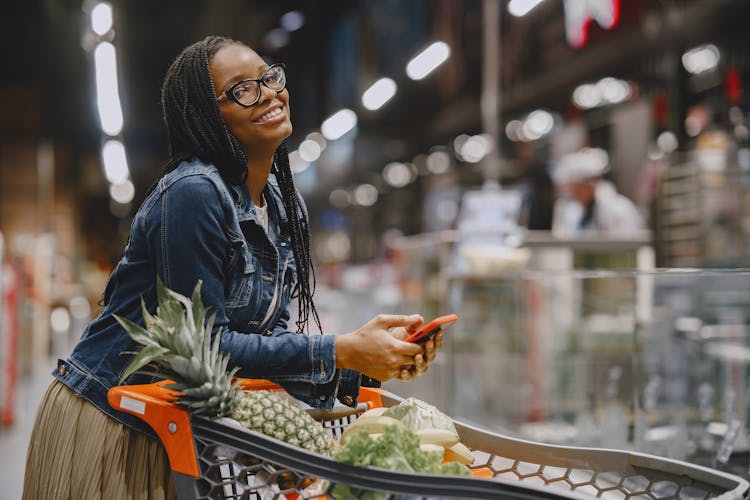 Smiling Woman Grocery Shopping In Supermarket