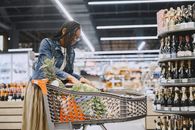 Woman in Blue Denim Jacket Holding Basket of Fruits