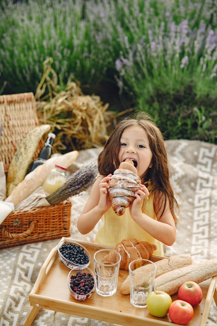 Girl Biting A Large Croissant