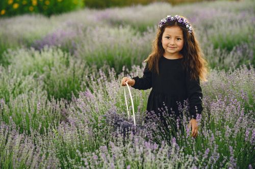 Free Young girl with flower crown smiling in a lavender field during summer. Stock Photo