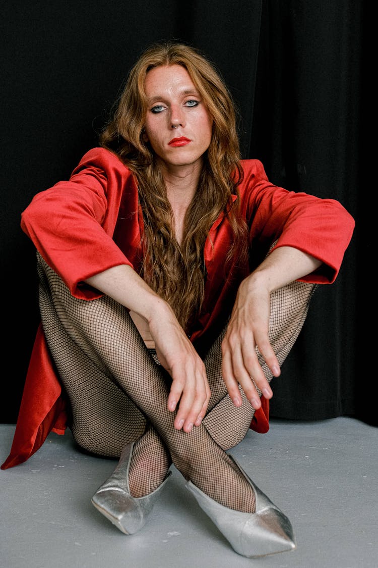 Tired Young Androgynous Guy In Extravagant Female Outfit Relaxing On Floor