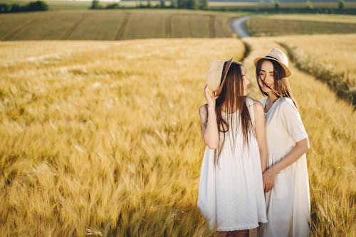 Women in White Dress Standing on Brown Grass Field
